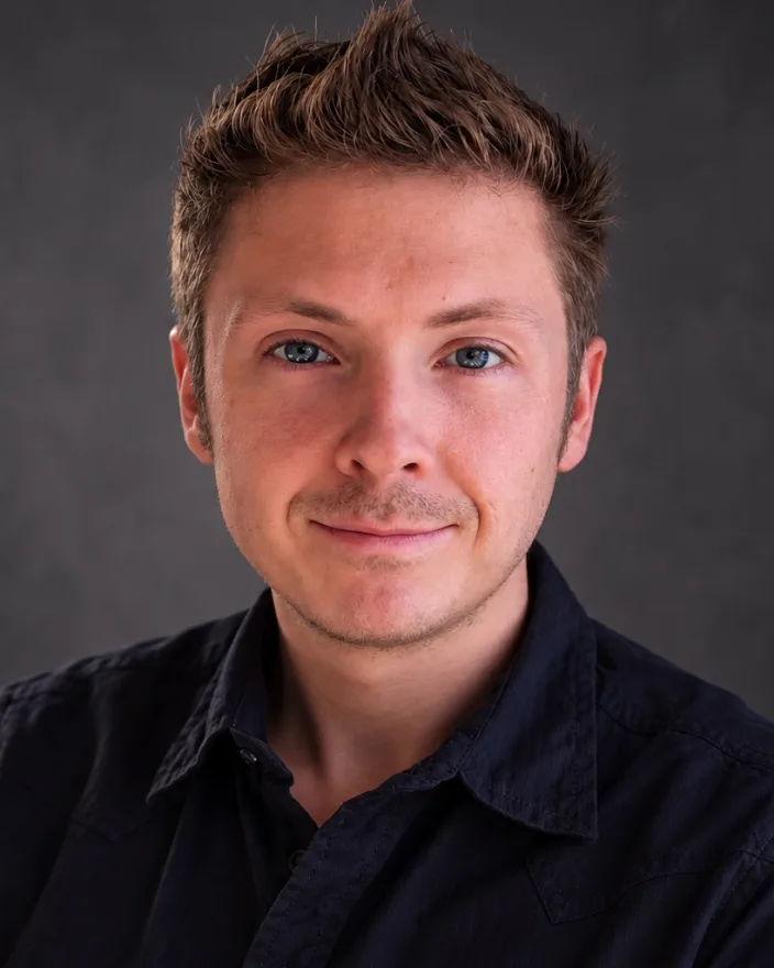 Milo Jennings, smiling, in a navy button-up shirt