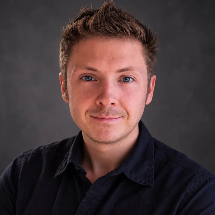 Milo Jennings, smiling, in a navy button-up shirt